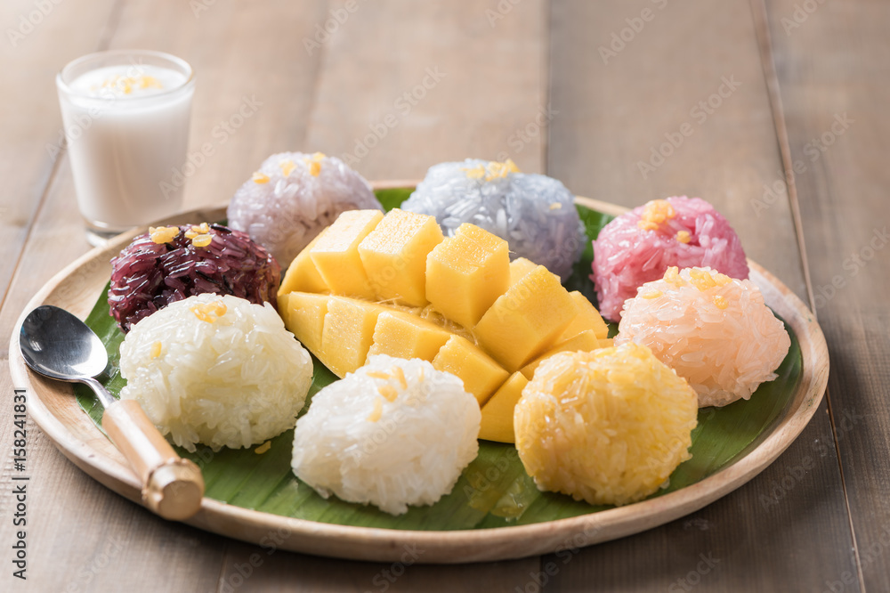 ripe mango with sticky rice on wood background