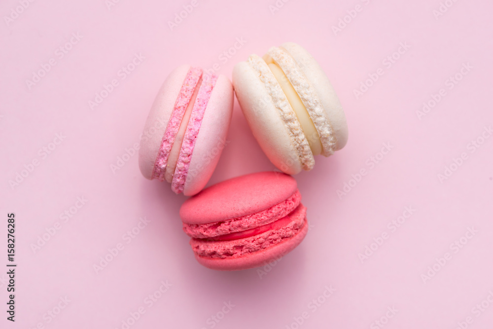 Tasty pink cake macaron or macaroon on pink background from above