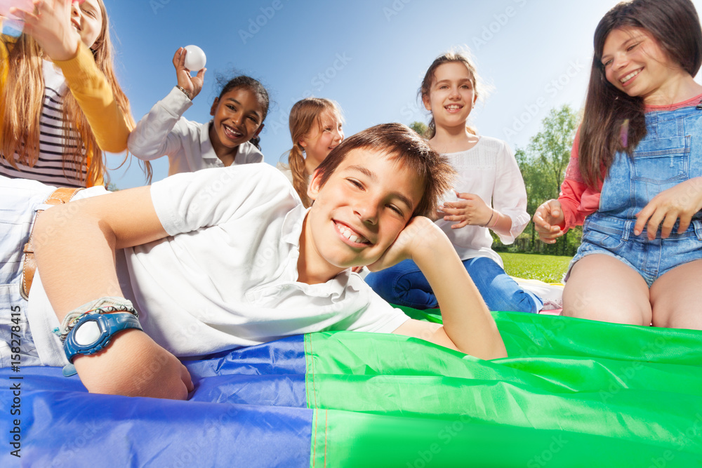 Happy boy laying on colorful mat in the park