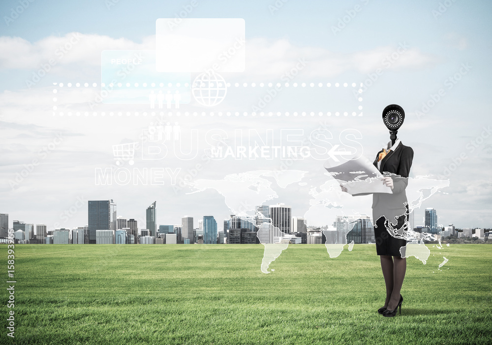 Camera headed woman standing on green grass against modern citys