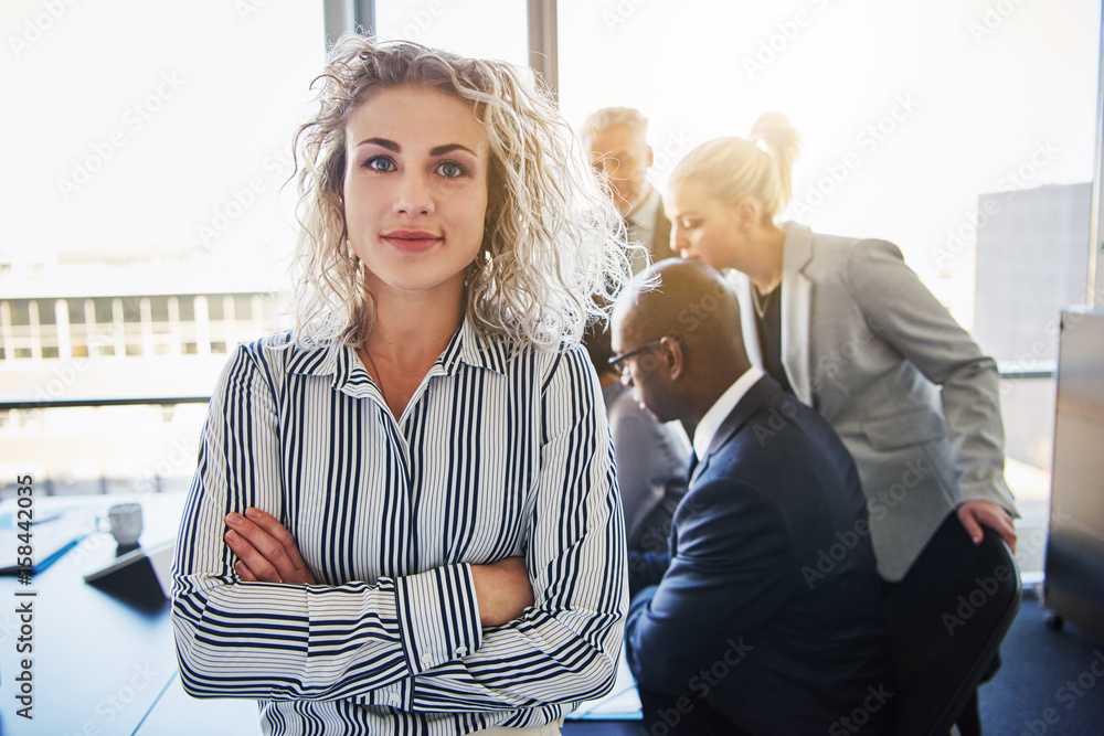 Business woman standing in front of team