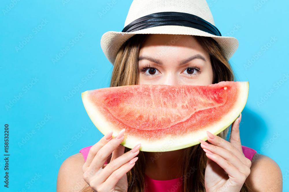 Happy young woman holding watermelon