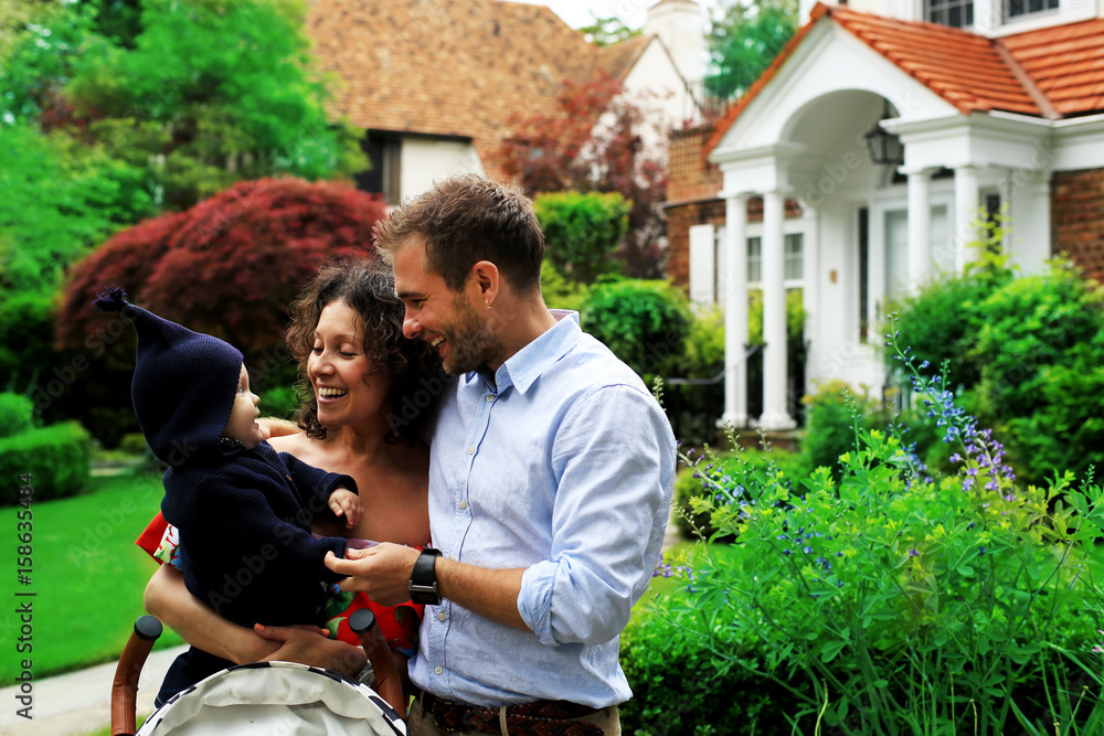 Young happy family on the street near house