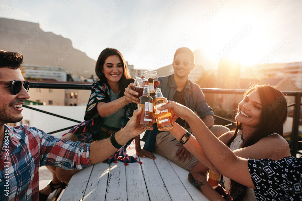 Friends toasting drinks at rooftop party