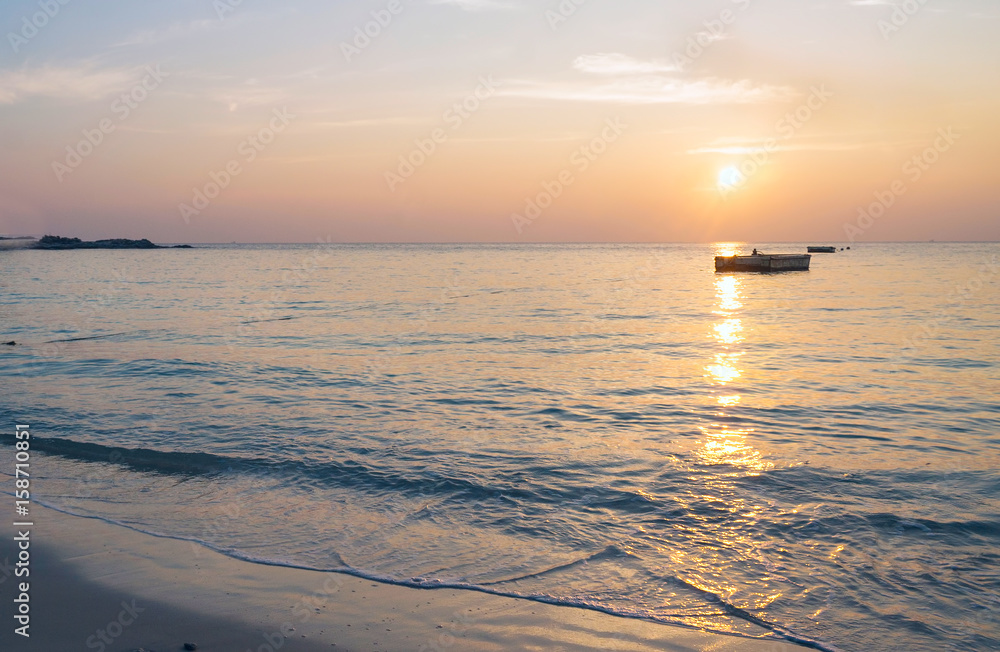 海上的黎明和一艘孤独的船。粉红色的温柔浪漫的风景。