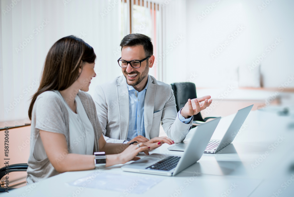 Colleagues working together at their desk in the office