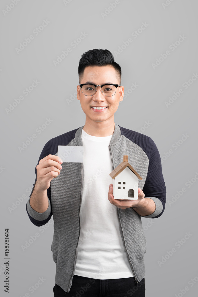 Businessman holding a blank card with an artificial model of the house