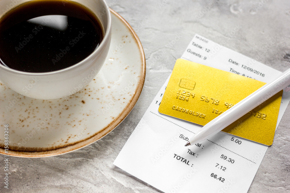 restaurant bill, card and coffee on stone table background