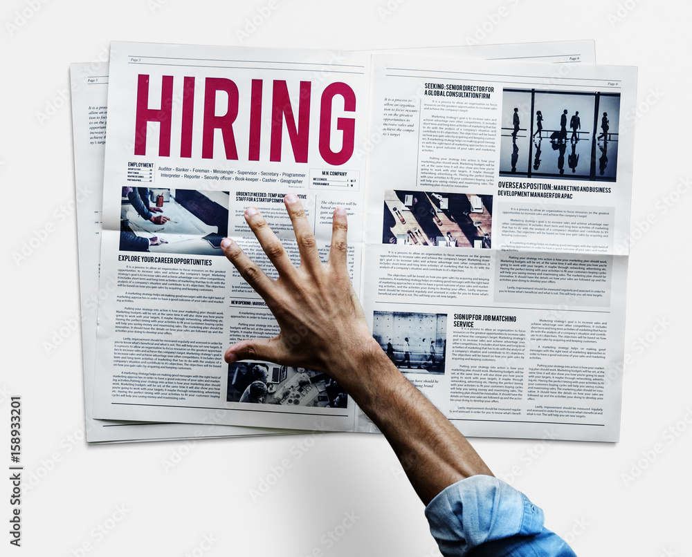 Hand reaching to grab newspaper for hiring job announcement