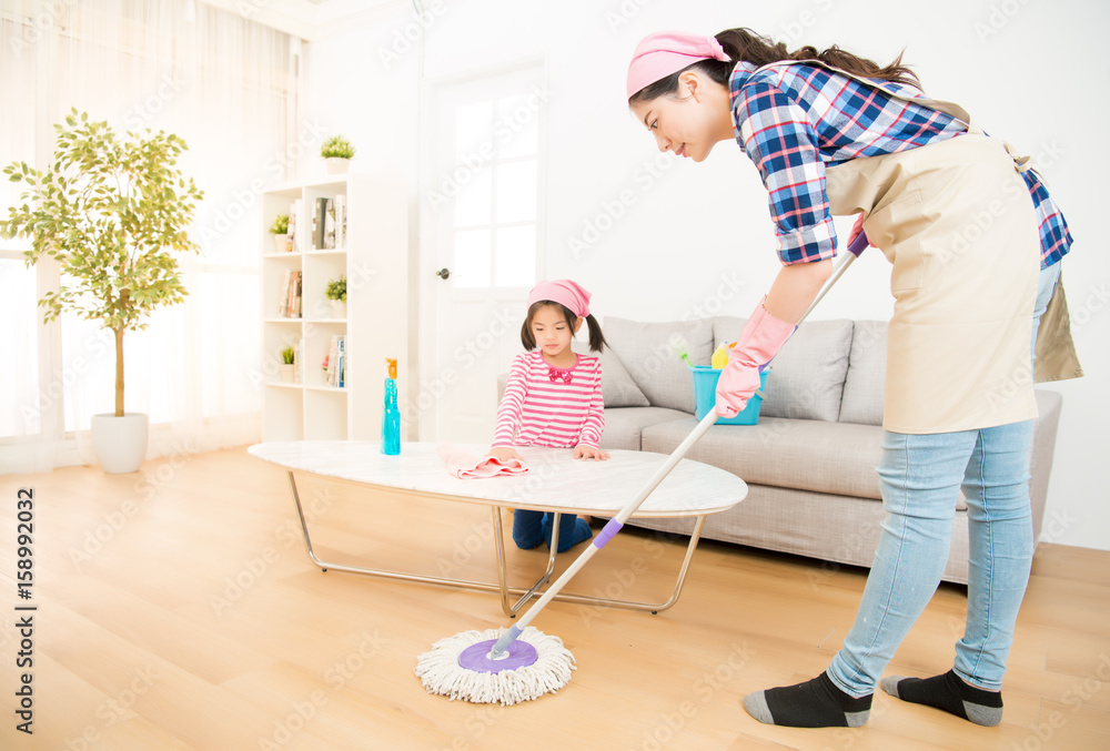 mum teaching daughter cleaning home