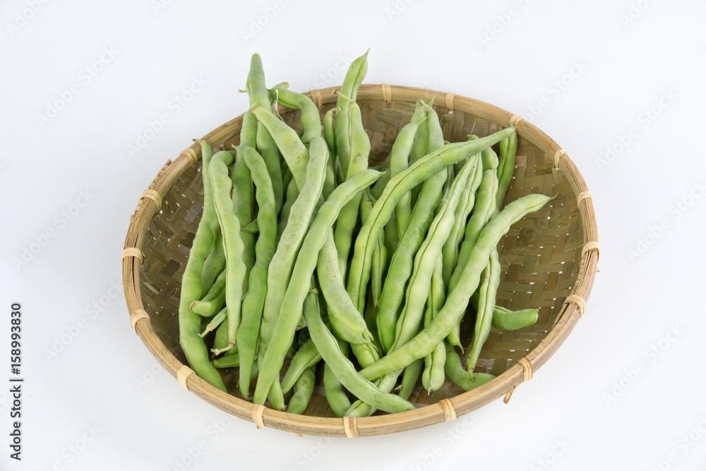 Green bean in a bamboo basket isolated on white background