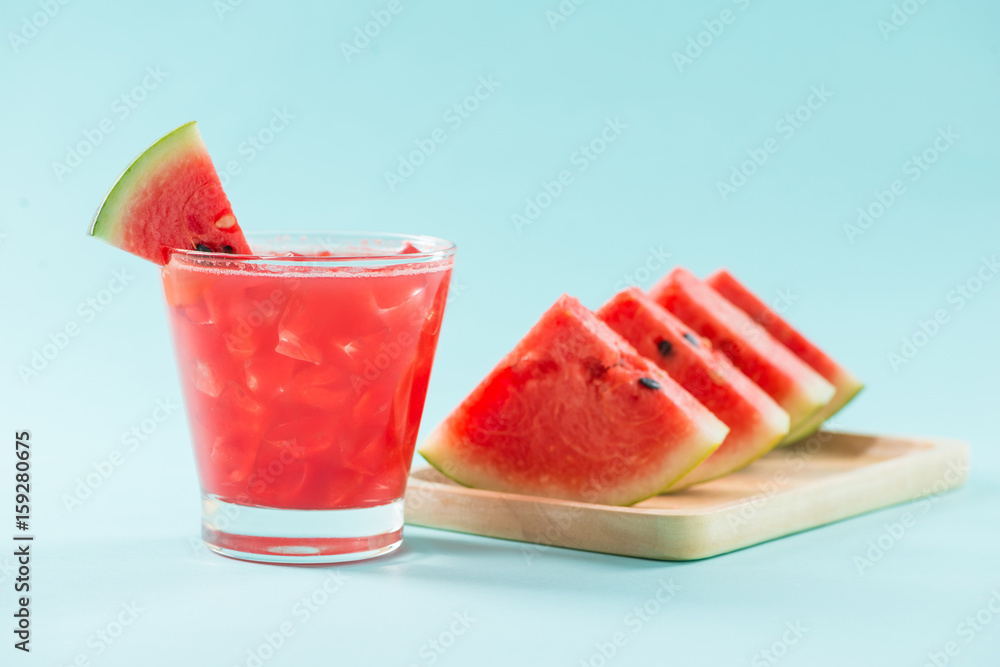 Glass of healthy watermelon juice in summertime on blue background.