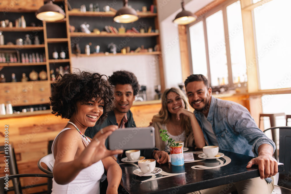 Group of friends at restaurant taking selfie