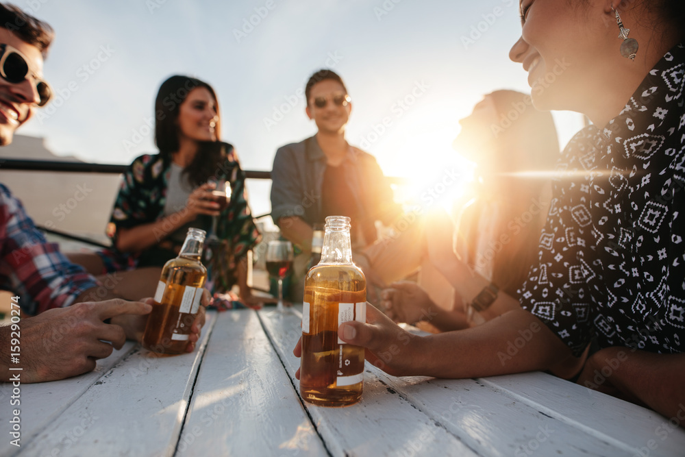 Young people sitting around a table with drinks