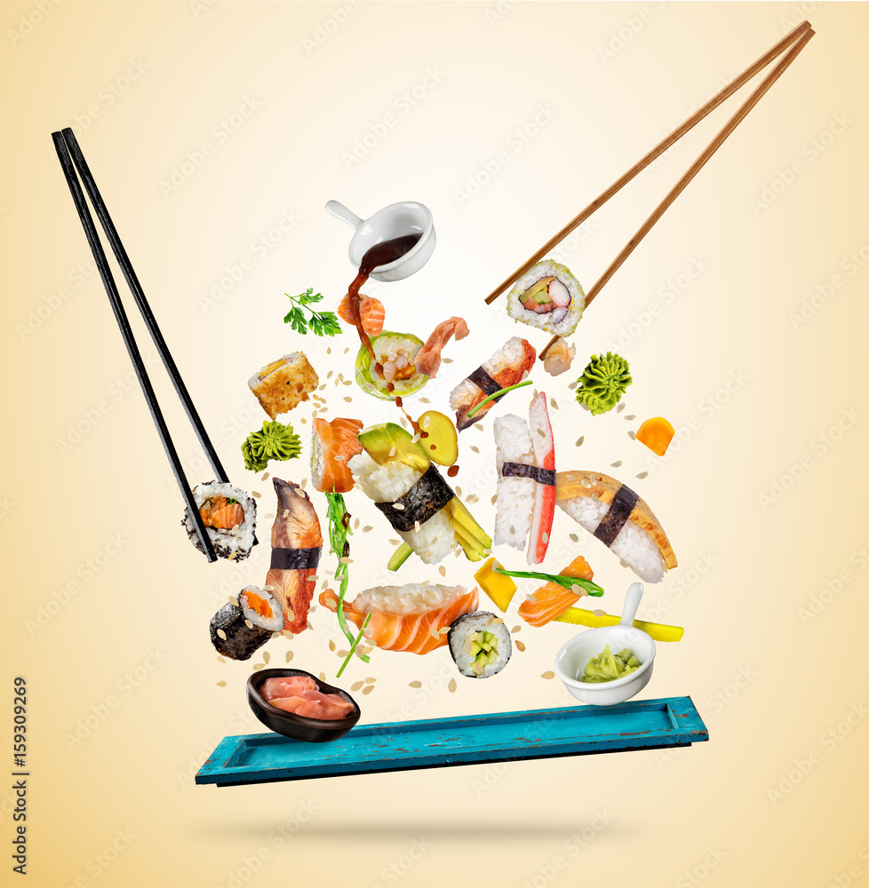 Flying sushi pieces served on wooden plate, separated on colored background. Many kinds of popular s