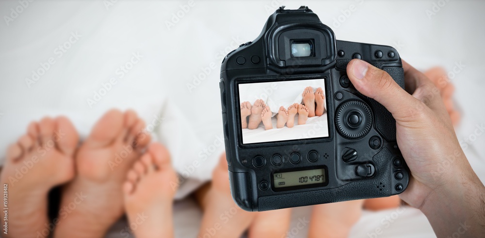 Composite image of cropped hand of photographer holding camera 