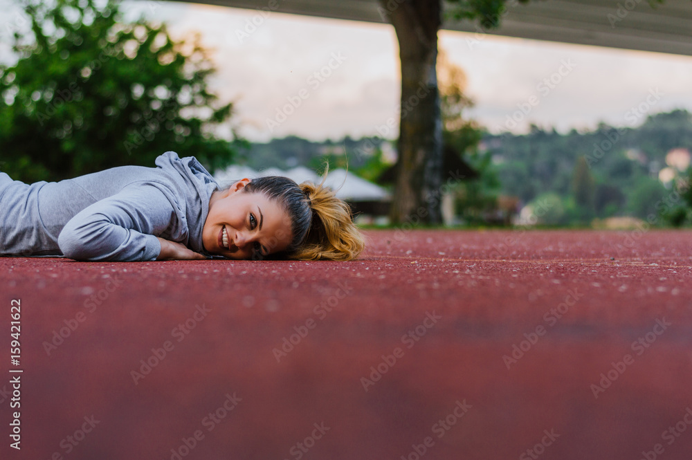 Athletic woman laying on running track