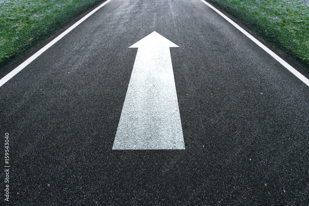 Road straight arrow direction sign on the asphalt ground.