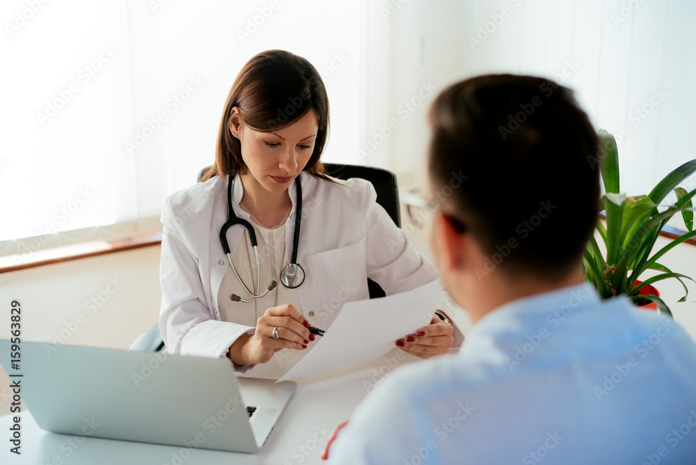 Serious woman doctor in pharmacy reading medical prescription to patient