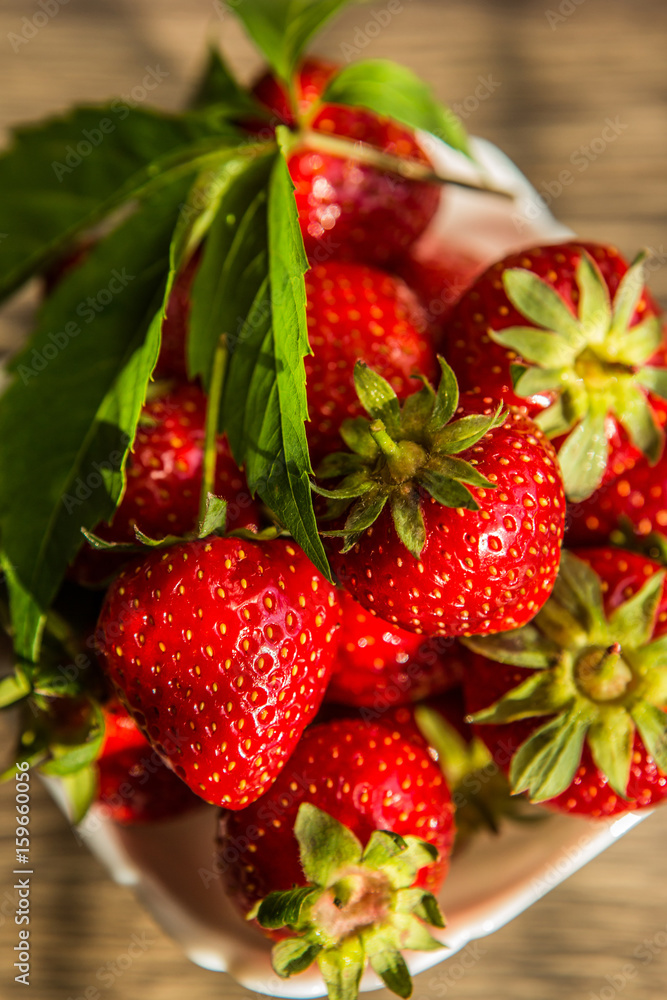 Ripe red strawberries. Bowl filled with juicy fresh ripe red strawberries. strawberries on a wooden 