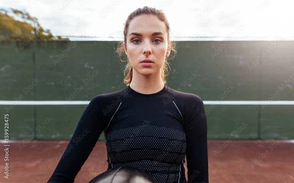 Portrait of young sportswoman on tennis court