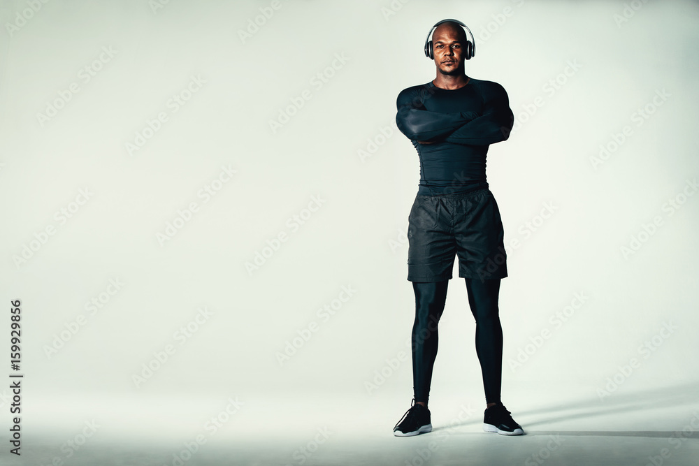 Muscular and fit male model standing on grey background