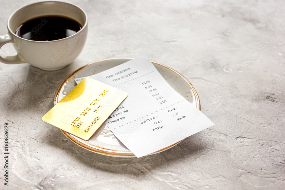 restaurant bill, card and coffee on stone table background