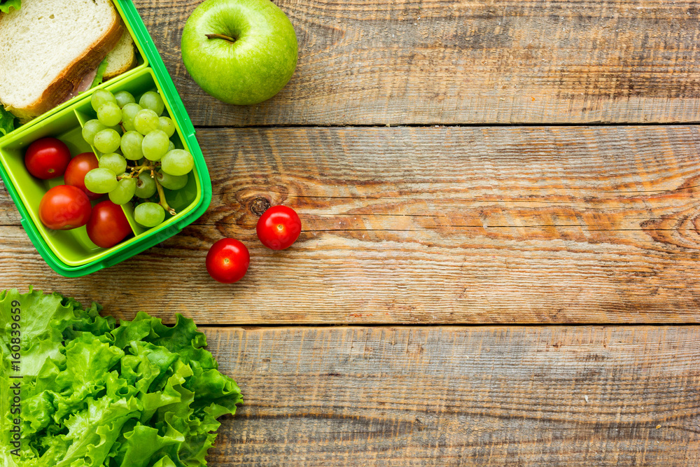 healthy break with apple, grape and sandwich in lunchbox on home table flat lay mock-up