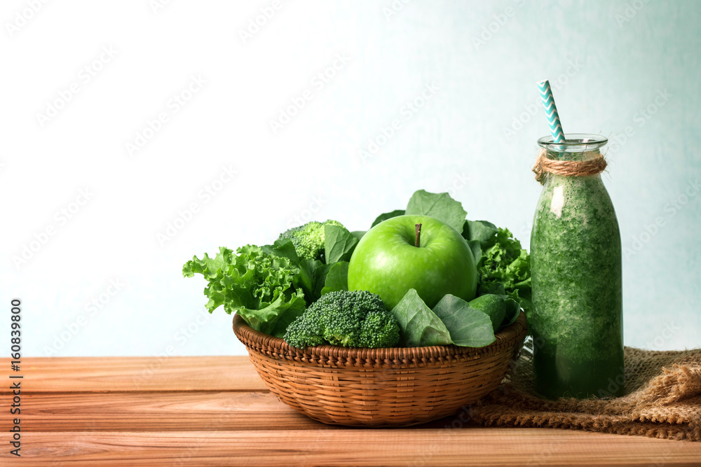 Healthy fresh  green smoothie juice in the glass bottle on wooden table with green apple and  vegeta