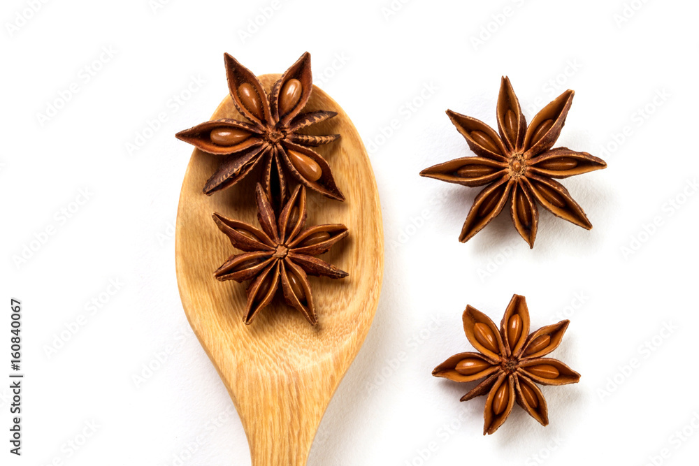 Close up the brown star anise spice in wooden spoon isolated on white background