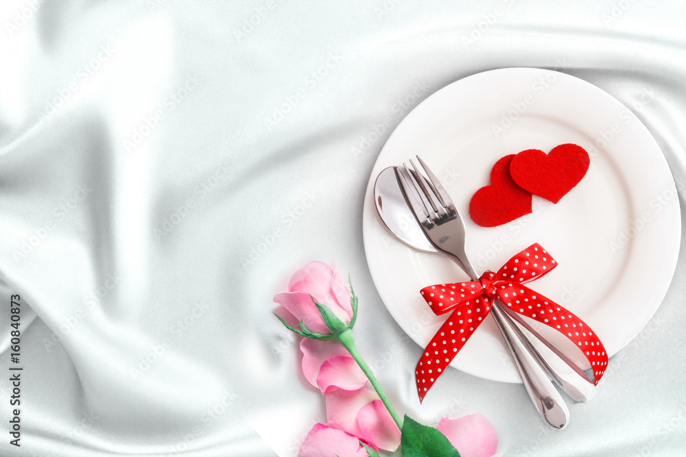 red heart shape with White empty plate with fork and spoon on white silk fabric for love dinner conc