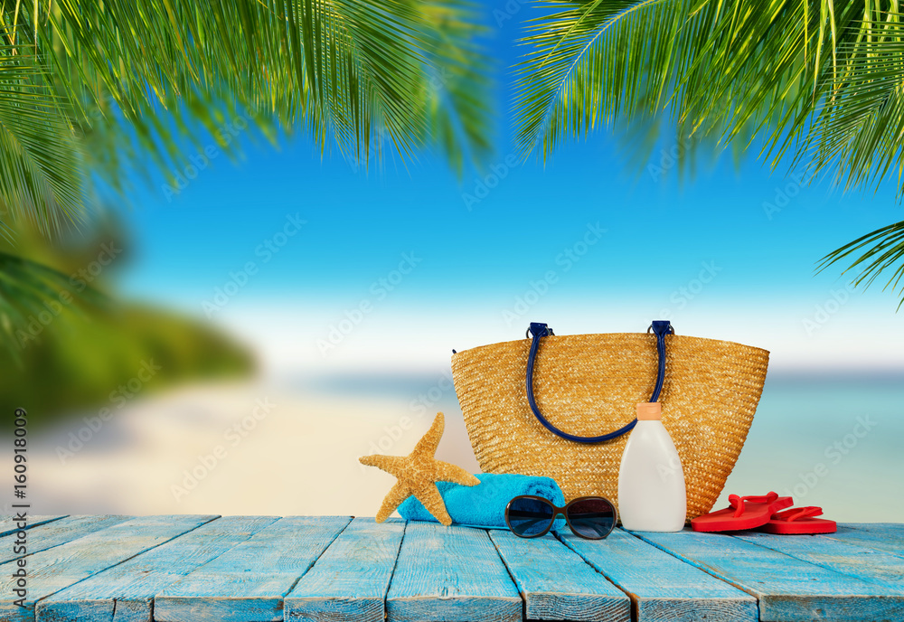 Tropical beach with accessories on wooden planks, summer holiday background.