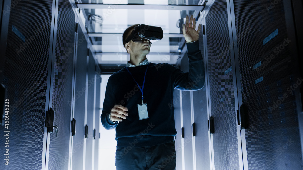 IT Engineer Wearing Virtual Reality Headset Works with Augmented Reality Software in Data Center. He