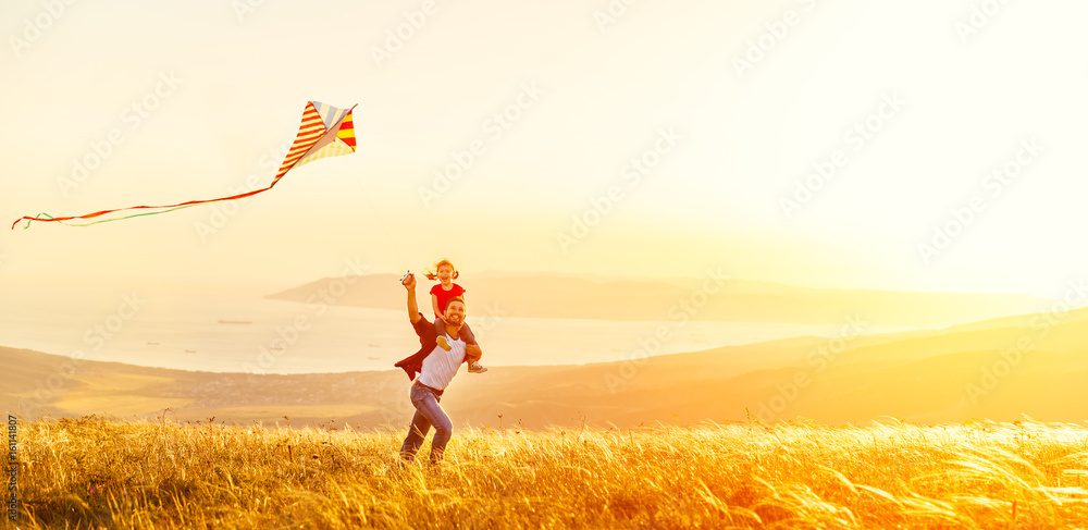 happy family father and baby daughter run with  kite on meadow.