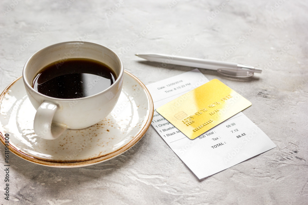 credit card for paying, coffee and check on cafe stone desk background