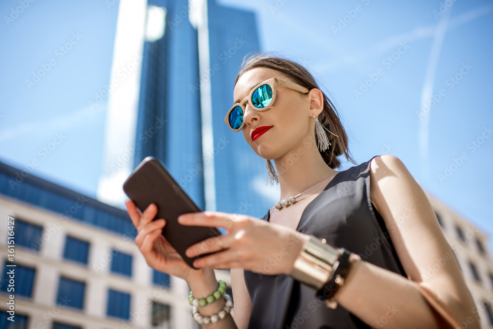 Lifestyle portrait of a businesswoman with phone in the modern district in Frankfurt city