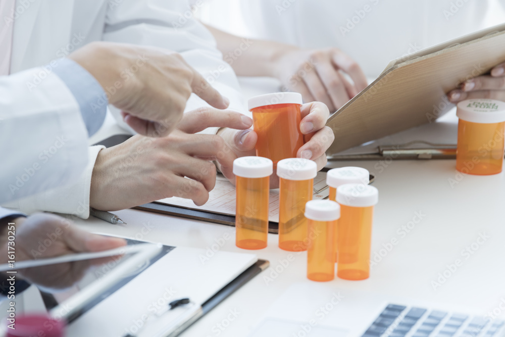 Doctor is lifting container of medicine