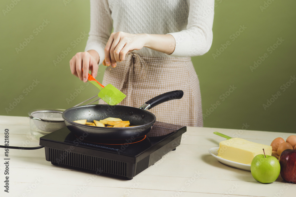 House wife wearing apron making. Steps of making cooking apple cake. Cutting green apple.