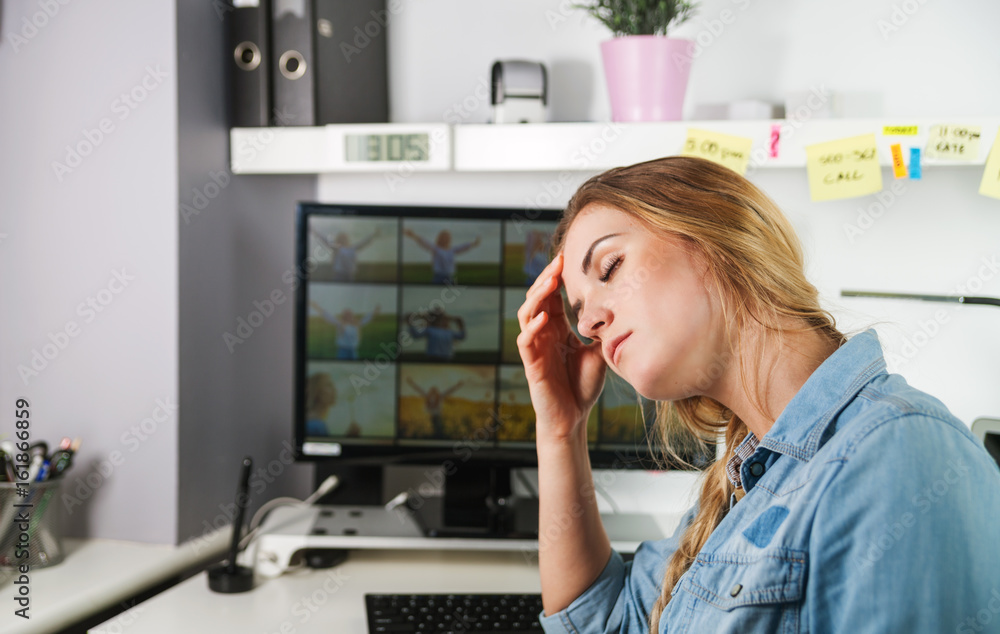 Tired woman working at home office desk