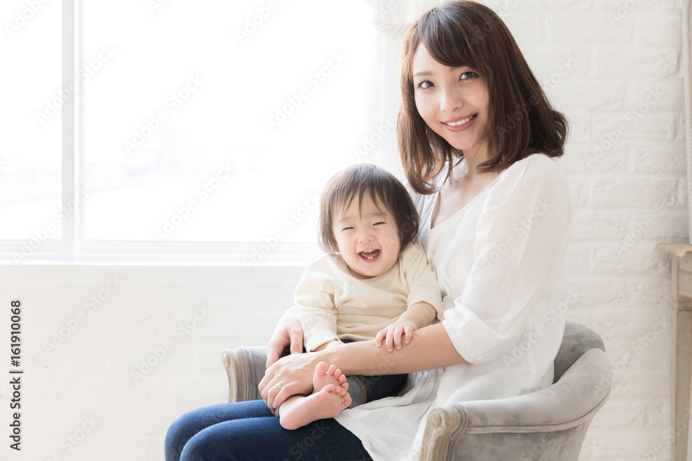 asian mother and child relaxing in living room