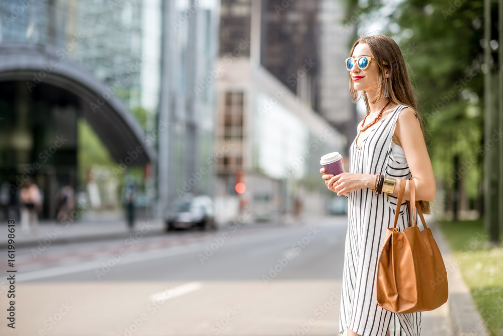 Young businesswoman having a coffee break standing outdoors on the street in Brussel city