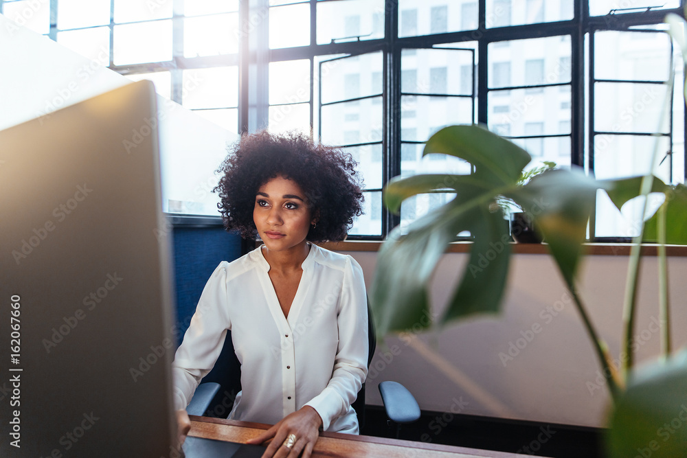 Young african woman working late in office