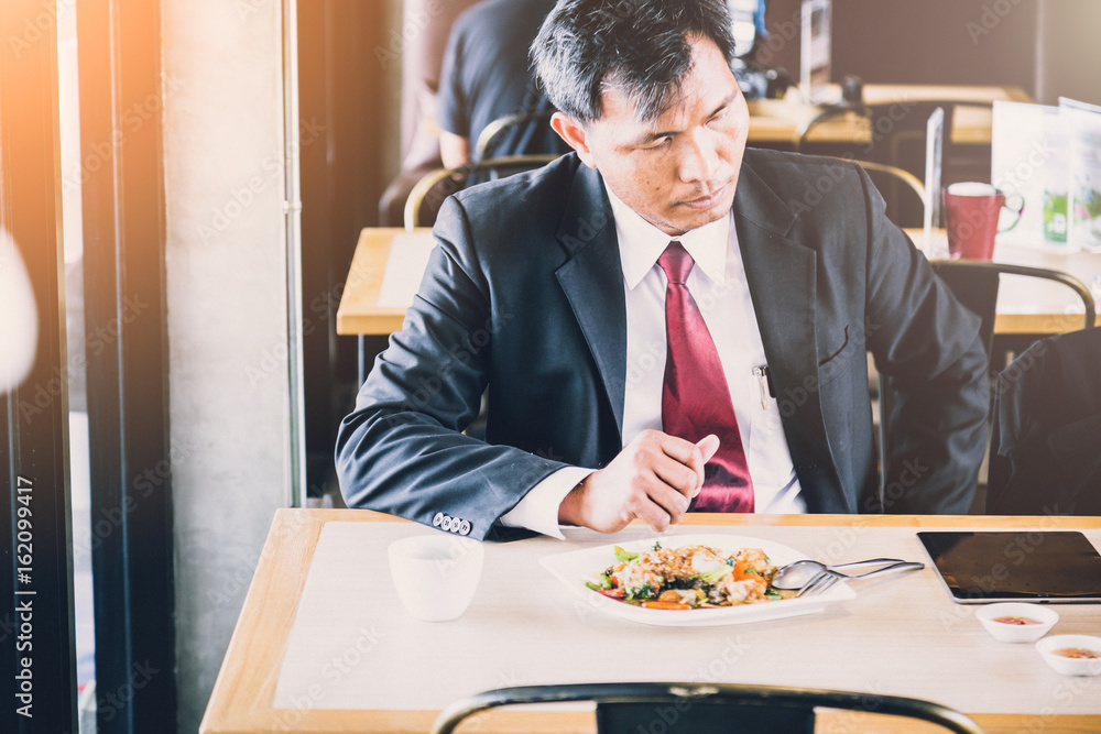 asian business man eating lunch with tablet