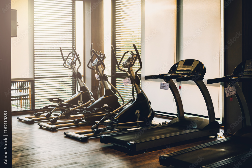 close up treadmill in fitness room background with color tone and light flare effect