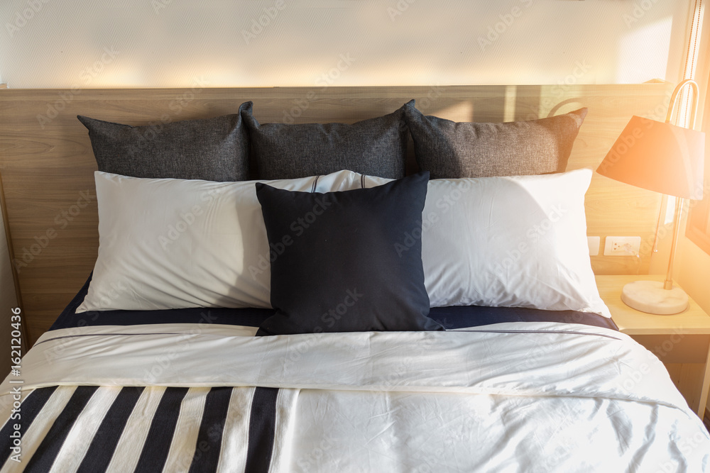 Bed maid-up with clean white pillows and bed sheets in beauty room. Close-up. Lens flair in sunlight