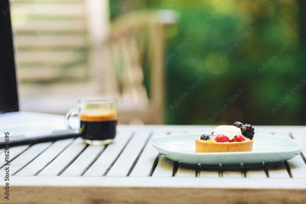 Desserts, coffee and laptop outside with a forest background