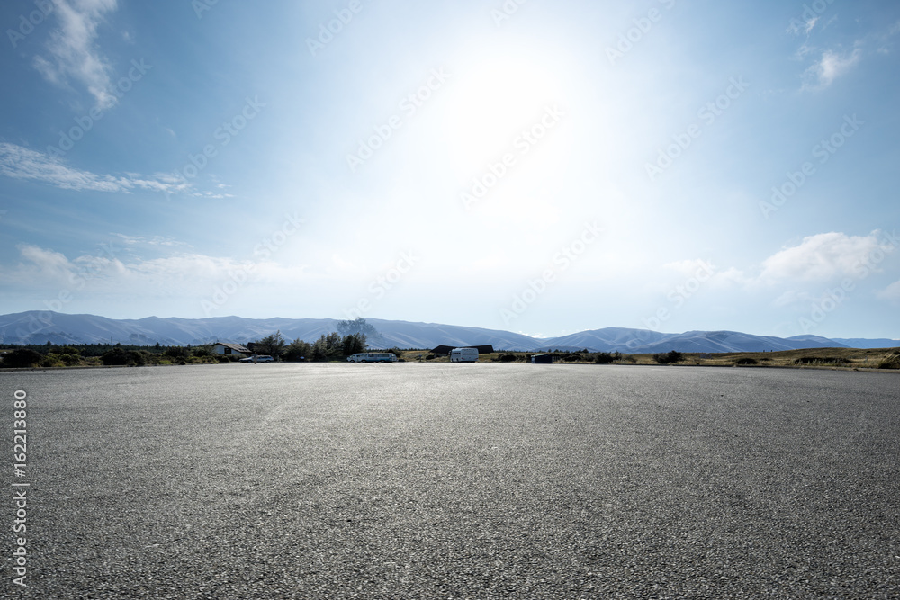 empty road near grassland with blue sky