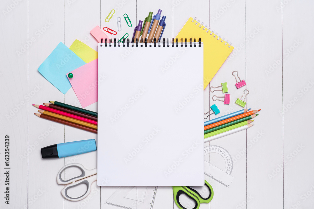 School stationery or office supplies on wood background.