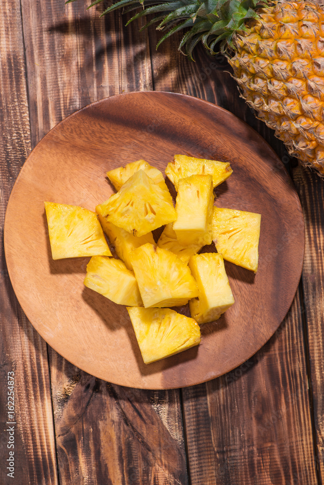 Tropical fruit concept. Cutted pineapple on the old wooden background.