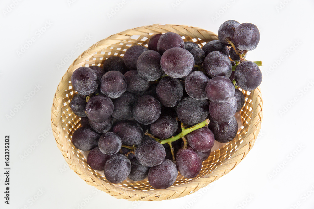 grapes in bamboo basket isolated on white background
